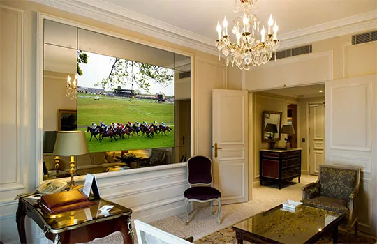 Television display concealed within a wall mirror